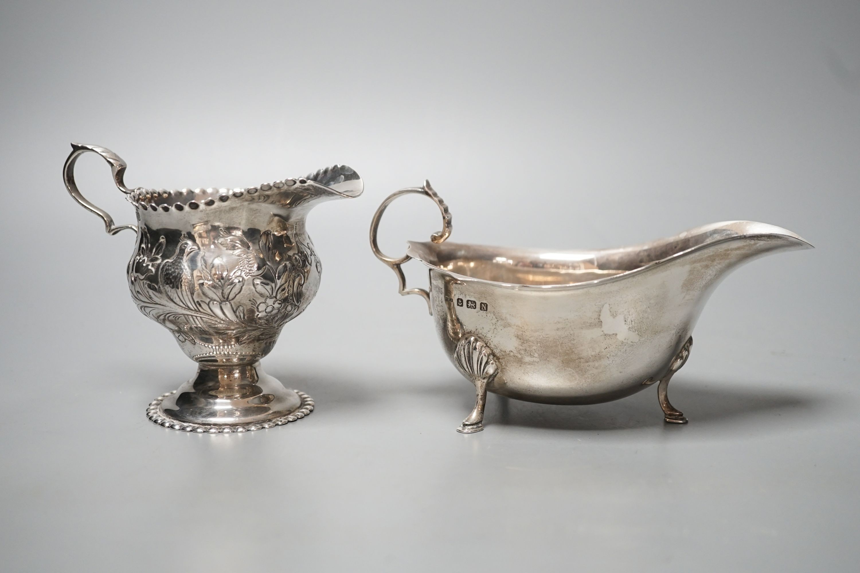 An Edwardian silver cream jug, Chester, 1904 and a late silver sauce boat, 9.5oz.